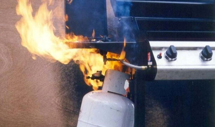 Close-up of a kitchen gas stove burner with a small flame, emphasizing domestic natural gas use.